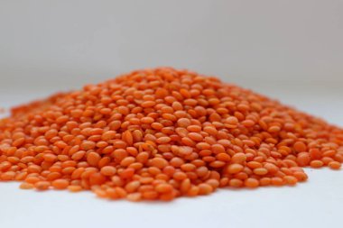 Beyaz arka plan konseptine yakın kırmızı mercimek, doğal protein besin, vejetaryen tarifler ve baklagilli mutfak estetiği.