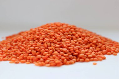 Beyaz arka plan konseptine yakın kırmızı mercimek, doğal protein besin, vejetaryen tarifler ve baklagilli mutfak estetiği.