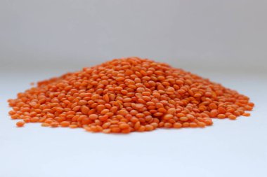 Beyaz arka plan konseptine yakın kırmızı mercimek, doğal protein besin, vejetaryen tarifler ve baklagilli mutfak estetiği.