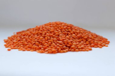 Beyaz arka plan konseptine yakın kırmızı mercimek, doğal protein besin, vejetaryen tarifler ve baklagilli mutfak estetiği.