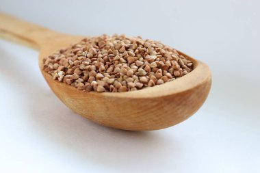 Karabuğday, tahta kaşıkta büyür, arka planda hafif beslenme, sağlıklı yaşam tarzı ve aşçılık sadeliği kavramına yakın çekim yapar.