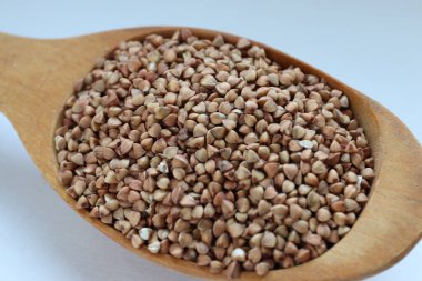 Karabuğday, tahta kaşıkta büyür, arka planda hafif beslenme, sağlıklı yaşam tarzı ve aşçılık sadeliği kavramına yakın çekim yapar.