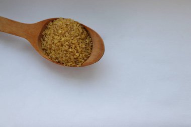 Tahta kaşıkta bulgur, sağlıklı beslenme için doğal tahıl, vejetaryen tarifler ve aşçılık estetiği.
