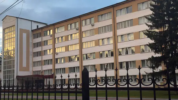 İkamet bölgesinde büyük pencereleri ve yeşil çevresi olan modern apartman.