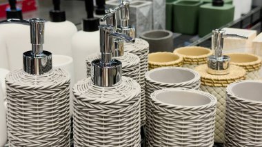 Dokuma sabun makineleri ve krom pompalı diş fırçası tutacakları olan şık banyo aksesuarları. Ev eşyaları reklamları, e-ticaret listeleri, organizasyon blogları için ideal imaj,