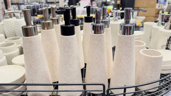 Benekli bej tasarımlı, siyah ya da gümüş tulumbalı ev eşyası aksesuarlarında, tel bir sepette dizayn edilmiş sabun dağıtıcılarının vitrinlerini göster.