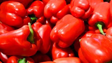 Parlak ciltli taze kırmızı dolma biberler mutfak tasarımı, tarım markaları, ambalajlar, yemek blogları ve sağlıklı beslenme içerikleri için canlı bir sebze arkaplanı..