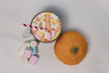 Beyaz arka planda şekerleme ve balkabağı olan kakao. Reklam içecekleri, yemek içeriği, sosyal medya ve şenlikli dekorasyonlar için samimi bir sonbahar kompozisyonu..