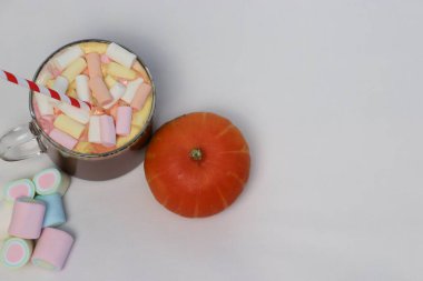 Hafif arka planda şekerleme ve balkabağı olan kakao. Reklam içecekleri, yemek içeriği, sosyal medya, kartpostallar ve mevsimsel tasarım için ılık bir sonbahar kompozisyonu..