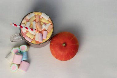 Beyaz arka planda şekerleme ve balkabağı olan kakao. Reklam içecekleri, yemek içeriği, sosyal medya ve şenlikli dekorasyonlar için samimi bir sonbahar kompozisyonu..