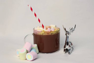 Beyaz arka planda marşmelovlu sıcak kakao bardağı ve şenlikli şeritli kamış Noel ve yeni yıl kartları, içecek reklamları, kahve dükkanlarının tanıtımları, tatil menüleri ve sıcak yaşam tarzı sosyal medya içeriği için mükemmel bir kış fotoğrafı.