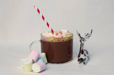 Beyaz arka planda marşmelovlu sıcak kakao bardağı ve şenlikli şeritli kamış Noel ve yeni yıl kartları, içecek reklamları, kahve dükkanlarının tanıtımları, tatil menüleri ve sıcak yaşam tarzı sosyal medya içeriği için mükemmel bir kış fotoğrafı.