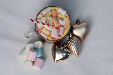 Noel süslerinin yanında marşmelovlu sıcak kakao ve çizgili kamış. Kalp ve çam kozalağı şeklinde. Tatil reklamları için mükemmel bir kış fotoğrafı.