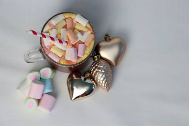 Noel süslerinin yanında marşmelovlu sıcak kakao ve çizgili kamış. Kalp ve çam kozalağı şeklinde. Tatil reklamları için mükemmel bir kış fotoğrafı.