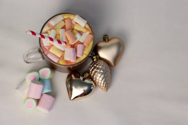 Noel süslerinin yanında marşmelovlu sıcak kakao ve çizgili kamış. Kalp ve çam kozalağı şeklinde. Tatil reklamları için mükemmel bir kış fotoğrafı.