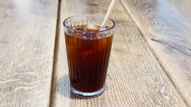 Buzlu kahvenin tazelenmesi, buz küpleri ile ahşap masa içeceği, kahve dükkanı konsepti, içecek reklamı, sağlıklı yaşam tarzı illüstrasyonu.