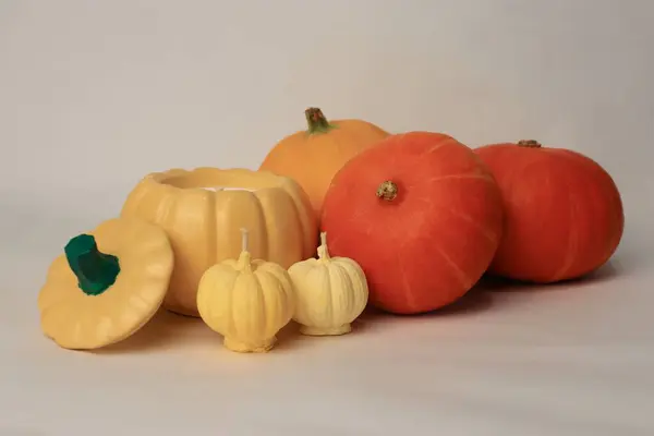 Sarı balkabağı şekilli mum ve renkli balkabağı kabakları Cadılar Bayramı için sonbahar süslemesi, hasat kutlaması, ve sıcak ev içi.