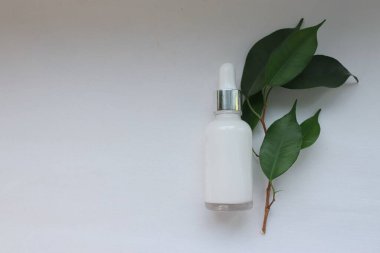 Beyaz arka planda damlatıcısı olan kozmetik serumu şişesi doğal organik cilt konsepti güzellik reklamcılığı, sağlık markası ve çevre dostu tasarım için.