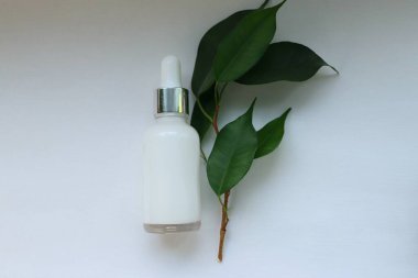 Beyaz arka planda damlatıcısı olan kozmetik serumu şişesi doğal organik cilt konsepti güzellik reklamcılığı, sağlık markası ve çevre dostu tasarım için.