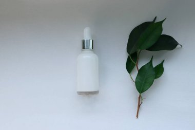 Beyaz arka planda damlatıcısı olan kozmetik serumu şişesi doğal organik cilt konsepti güzellik reklamcılığı, sağlık markası ve çevre dostu tasarım için.