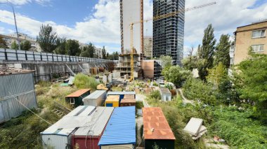 Ön planda kule vinci ve geçici konteynırları olan modern yüksek binaların inşaat alanı