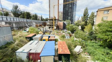 Ön planda kule vinci ve geçici konteynırları olan modern yüksek binaların inşaat alanı