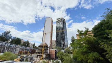 Ön planda kule vinci ve geçici konteynırları olan modern yüksek binaların inşaat alanı