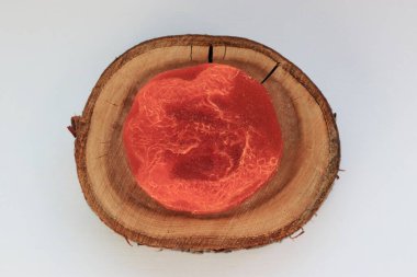 Doğal kırmızı el yapımı sabun ve içinde lifler olan ahşap bir tezgah. Minimalist ve çevre dostu organik kozmetik ürünler.