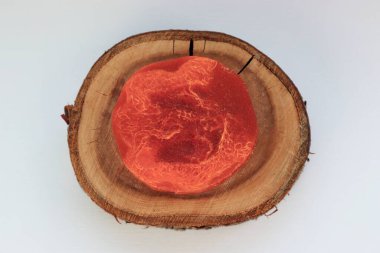 Doğal kırmızı el yapımı sabun ve içinde lifler olan ahşap bir tezgah. Minimalist ve çevre dostu organik kozmetik ürünler.