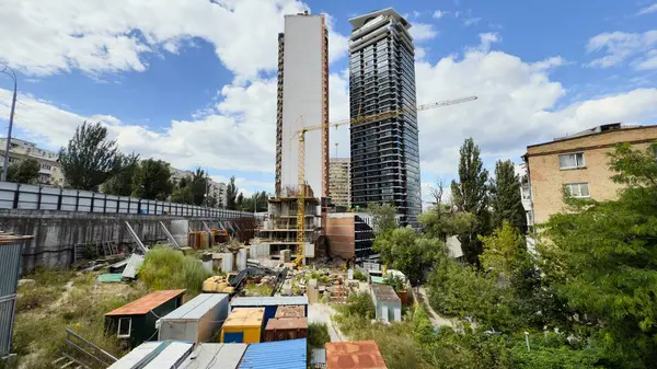 Ön planda kule vinci ve geçici konteynırları olan modern yüksek binaların inşaat alanı