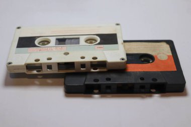 Hafif bir arkaplanda iki klasik ses kaseti analog dönemin, müzik nostaljisinin ve yaratıcı projeler için retro tasarımın sembolü..