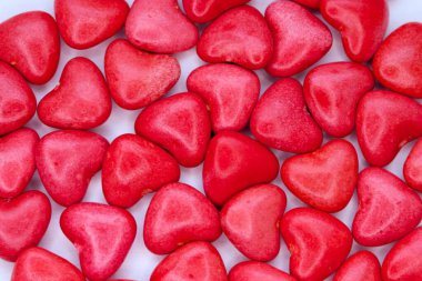 Heart-shaped red candies on a white background  a concept of love, romance, and festive mood for design, marketing, and emotional content