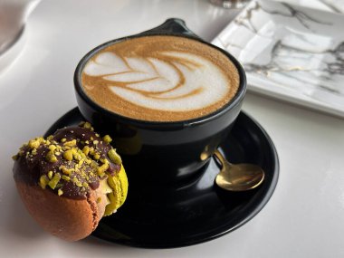 Bir fincan sade kahve, yanında da sanat eseri ve makarnalı kahve. Yüksek kalite fotoğraf