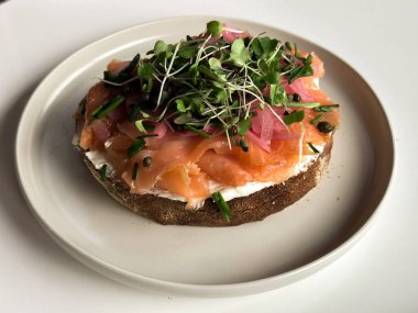 Taze, somonlu lezzetli sandviç ve beyaz tabakta taze yeşillikler. Yüksek kalite fotoğraf