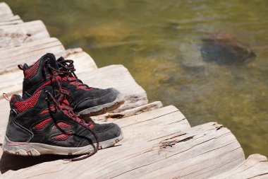 Nehrin üzerindeki ahşap bir köprüde çocuk yürüyüş botları.