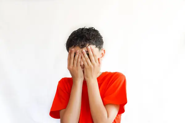 Stock image child, preteen, on a white , with freckles, with a gesture or pose of covering his face with his hands