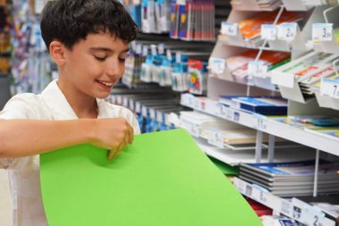 Ergen çocuk okul gereçleri için alışveriş yapıyor. okul konseptine geri dön