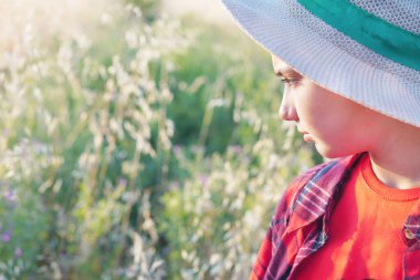 Sahadaki çocuk bitki örtüsünü gözlemliyor.