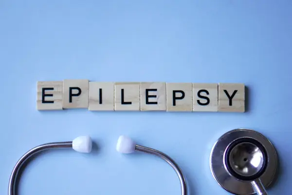 EPILEPSY, harfli ahşap bloklar ve açık mavi arka planlı steteskop. tıp konsepti