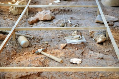 Aletlerle yapılan bir kazının ızgarası. arkeoloji ve paleontoloji kavramı
