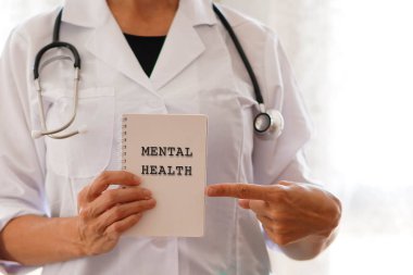 Yüzsüz kadın doktor işaret parmağıyla zihinsel sağlık kelimelerini işaret ediyor.