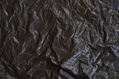 Buruşmuş siyah plastik desenli arka plan. Çöp torbası