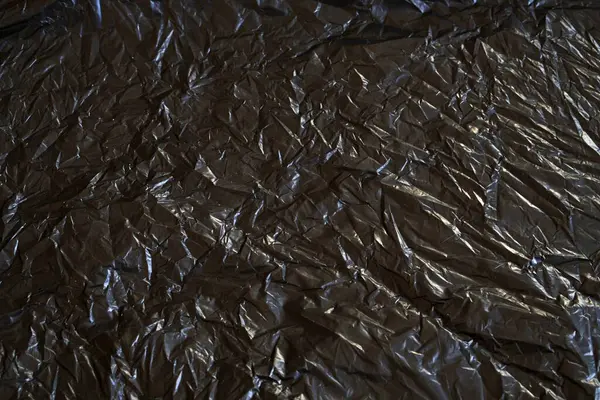 Buruşmuş siyah plastik desenli arka plan. Çöp torbası