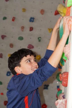 Tırmanma pratiği yapan genç bir çocuğun yakın çekimi. Spor ve sağlıklı çocukluk