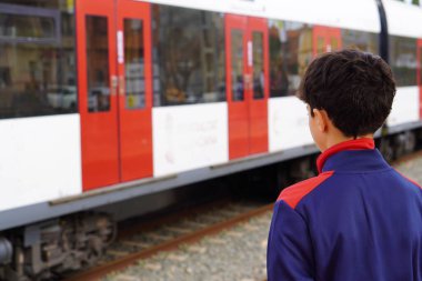 Metroda ya da tramvayda ergenlik çağında. Toplu taşıma için bekliyor.