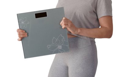 Gri spor elbiseli, elinde tartı olan bir kadının yüzsüz görüntüsü. beyaz arkaplan