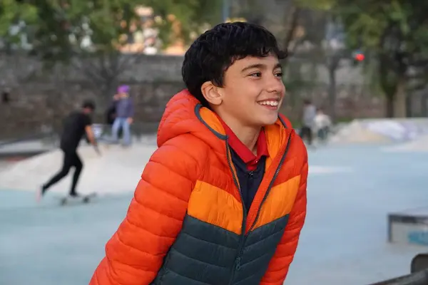 Çocuk kaykay parkında mutlu bir şekilde paten kaymayı öğreniyor.