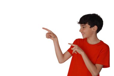 Mutlu genç çocuk iki eliyle bir tarafı işaret ediyor. kırmızı tişört ve beyaz arkaplan.