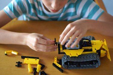 Evde hobisi olan genç bir çocuk. yaratıcılık, yapboz ve parçaların oyunları