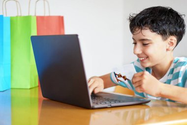 İnternetten alışveriş için video oyunu hediye kartları. Bilgisayarında hediye kartı olan genç bir çocuk..